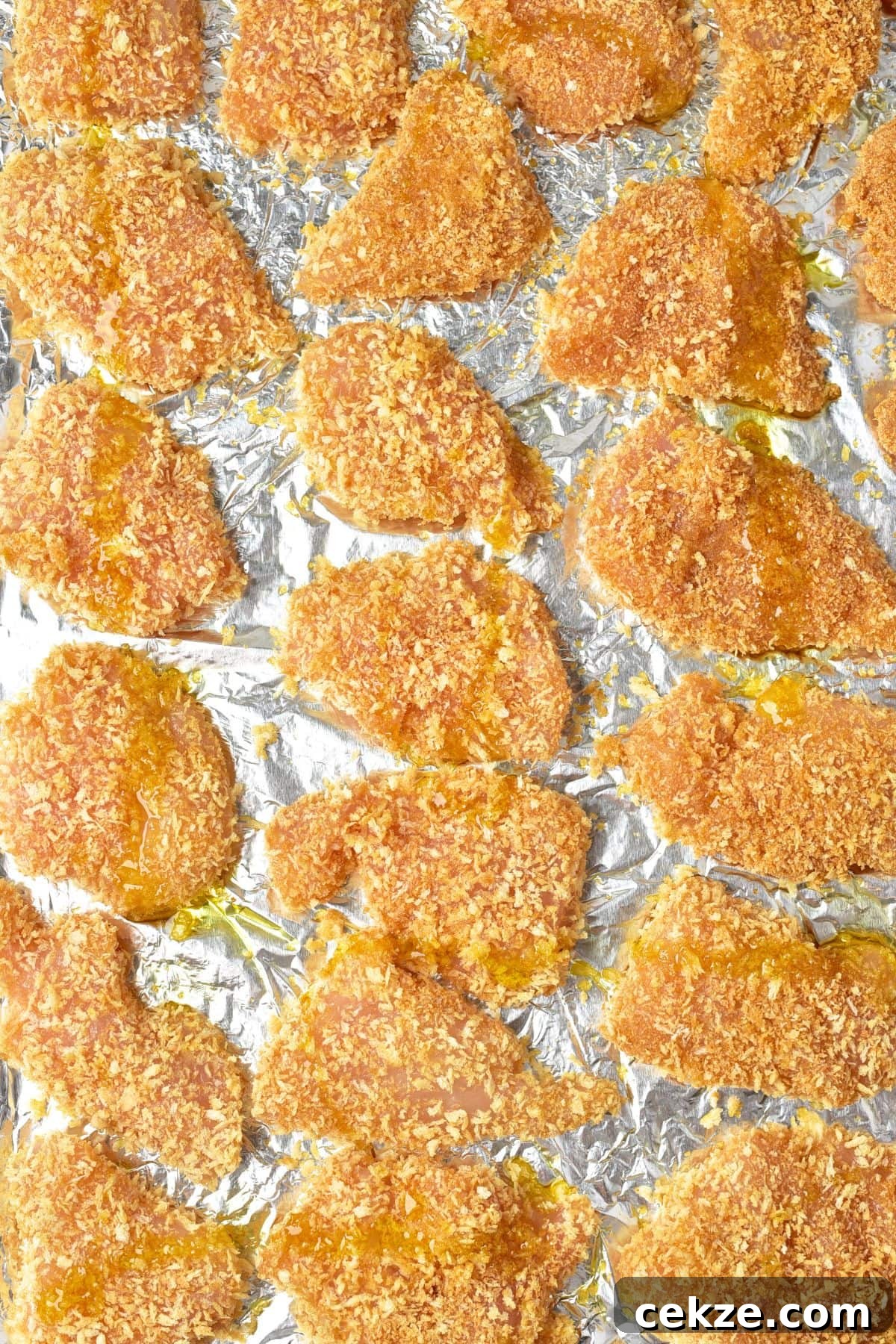 Homemade Turkey Nuggets (Gluten-Free, Dairy-Free) Bread crumb coated turkey pieces on aluminum foil.
