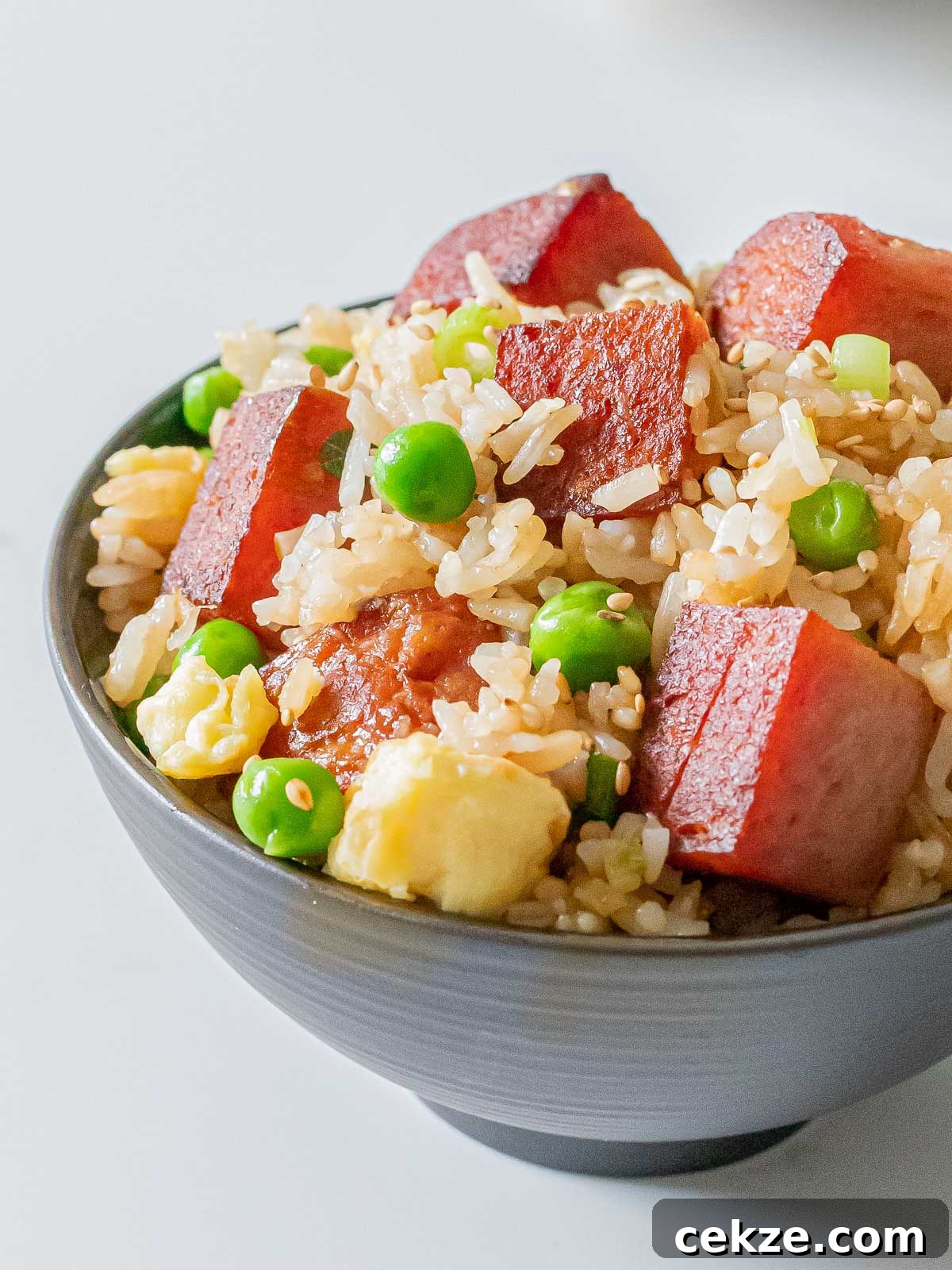 bowl of spam fried rice with eggs, green peas, and crispy cubes of spam