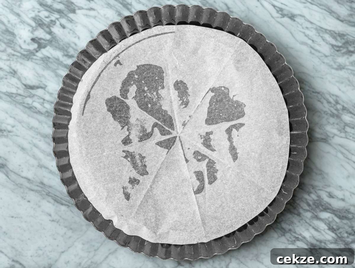 Tart pan lined with parchment paper.