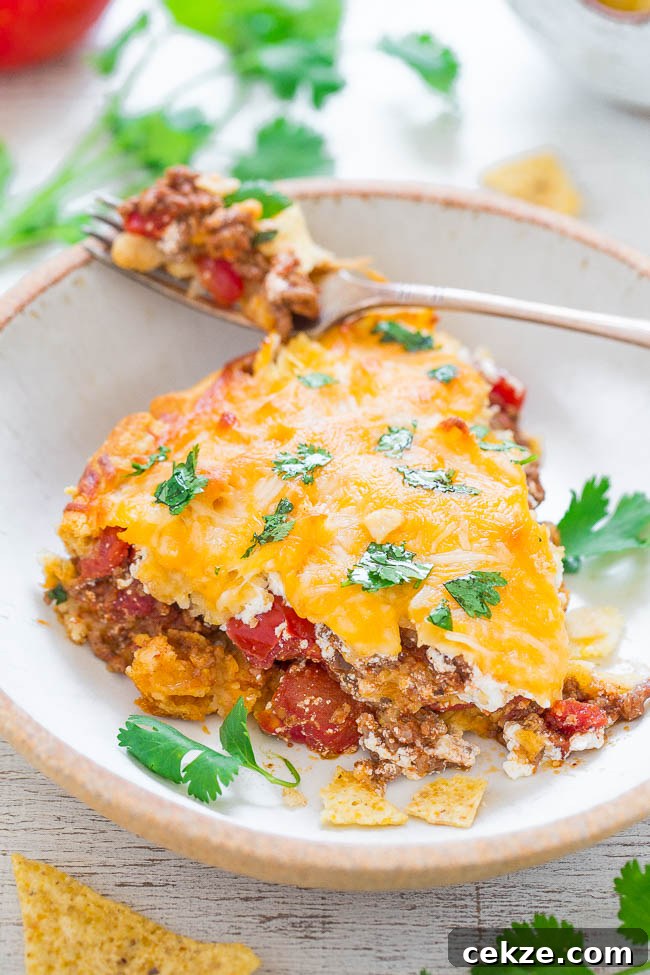 slice of Beef Taco Pie on plate with fork.