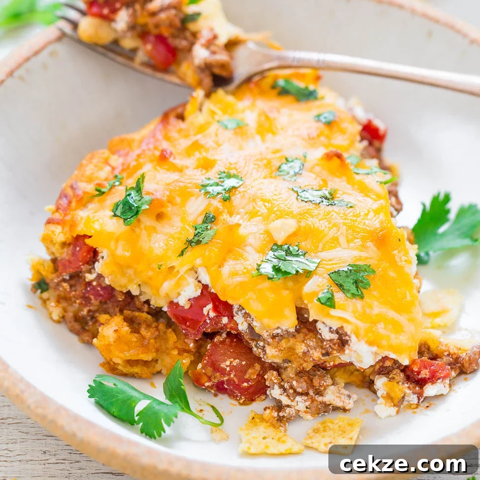 A slice of cheesy beef taco pie topped with cilantro.