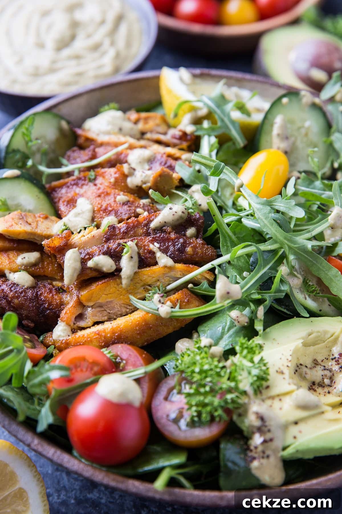 Top Chicken Thigh Recipes for Flavorful Weeknight Dinners 14 Close up image of crispy Mediterranean chicken salad with fresh vegetables and dressing on top.
