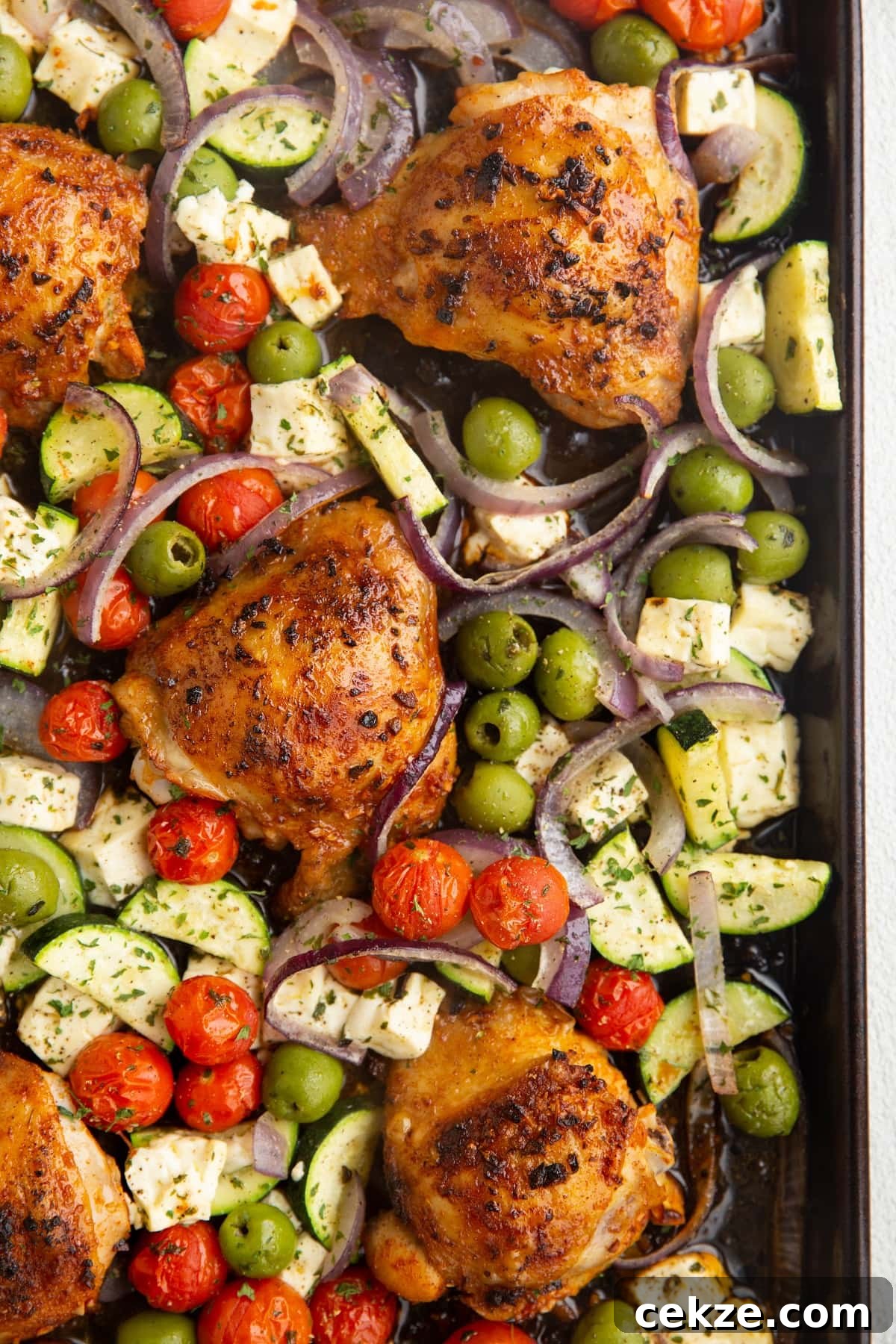 Top Chicken Thigh Recipes for Flavorful Weeknight Dinners 25 Cooked chicken thighs and vegetables on a sheet pan, ready to enjoy.