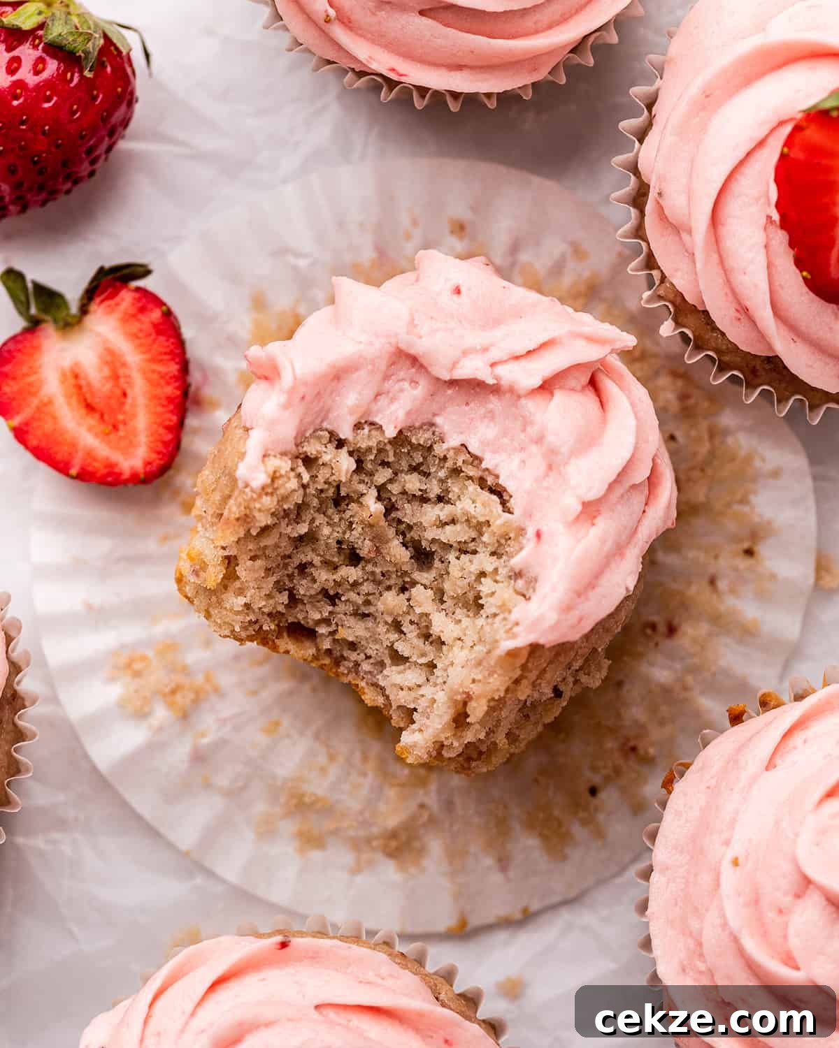 a frosted Strawberry Cupcake with a bite taken out of it