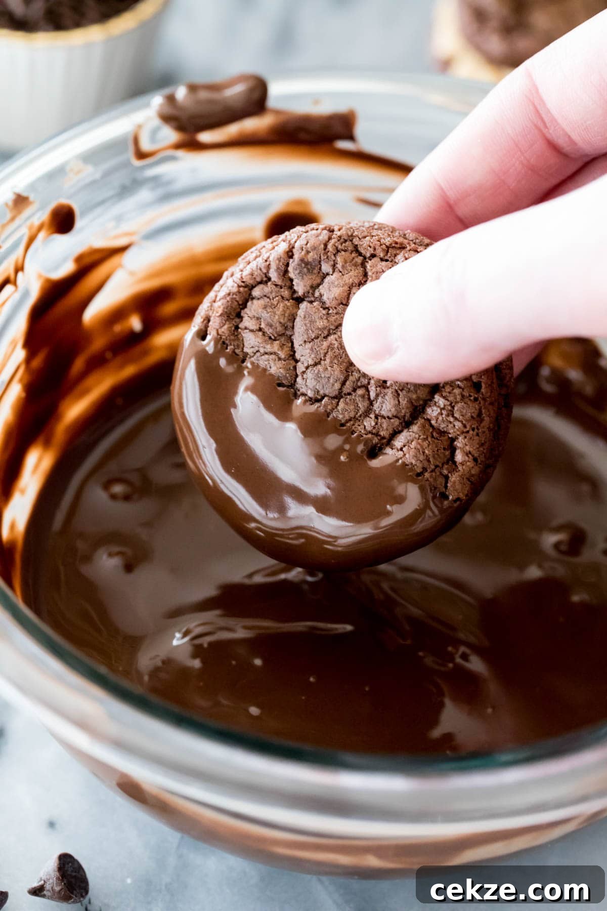 dipping sandwich cookie in melted chocolate