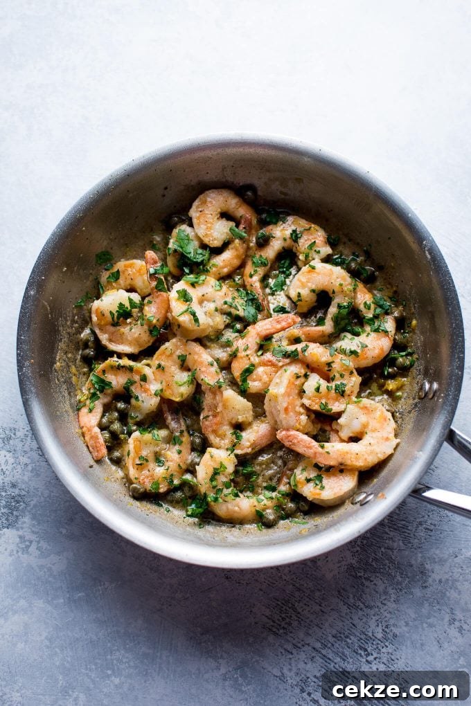 metal skillet with shrimp, lemon, butter, and capers