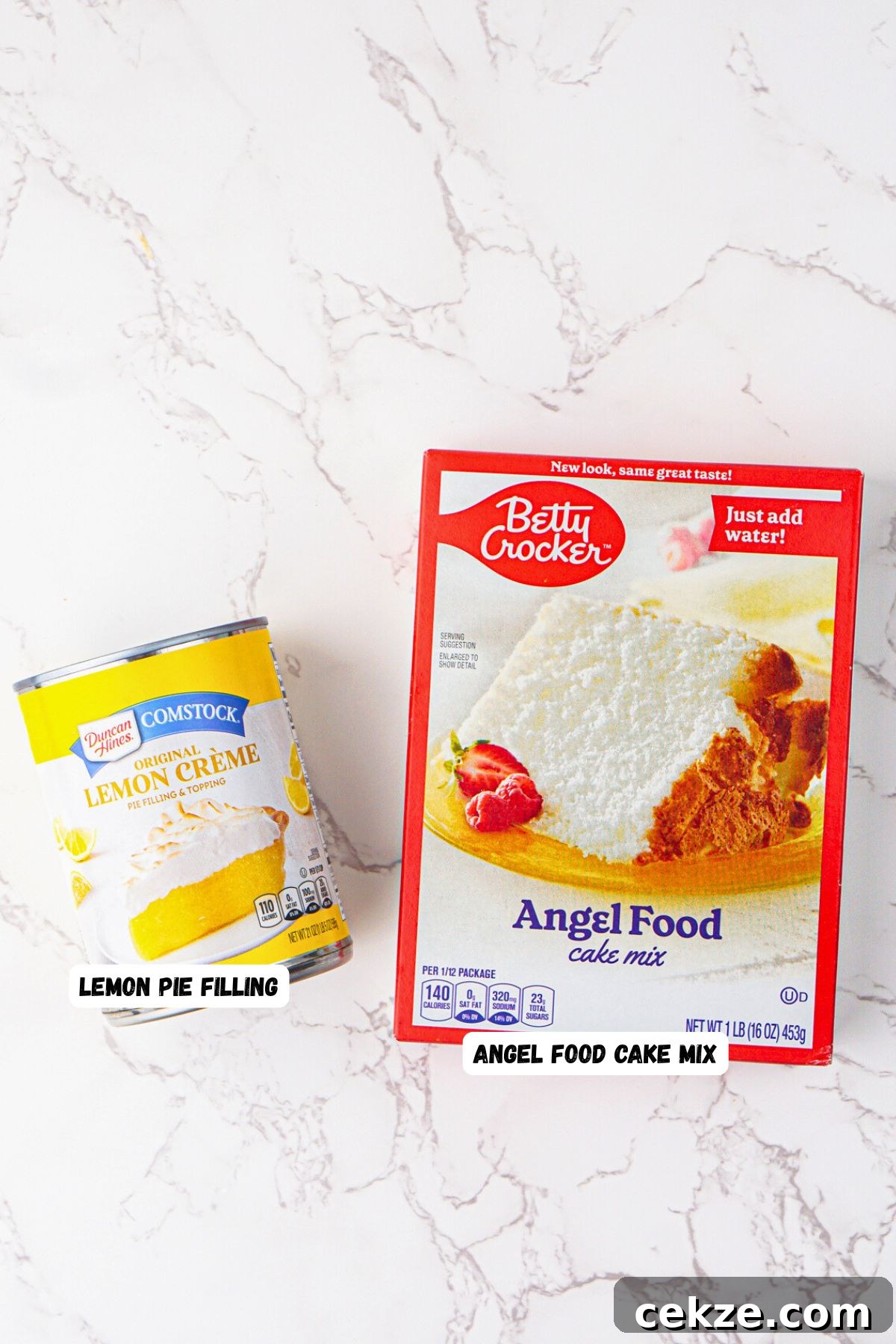 2-Ingredient Lemon Bars Recipe — Quick Tangy Dessert 3 Box of angel food cake mix and can of lemon pie filling on a white marble table.