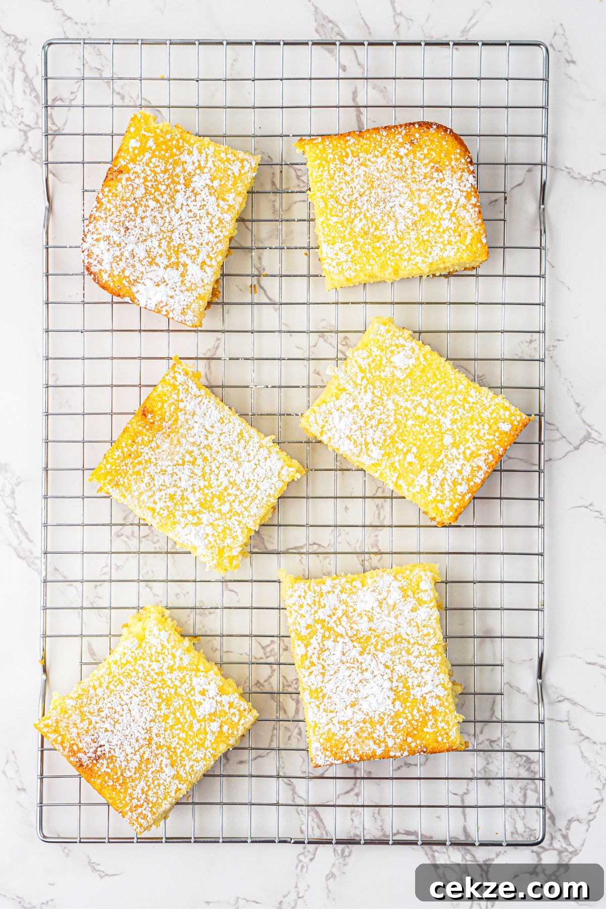 2-Ingredient Lemon Bars Recipe — Quick Tangy Dessert 7 Bright yellow lemon bars baked and cooling on a wire rack.