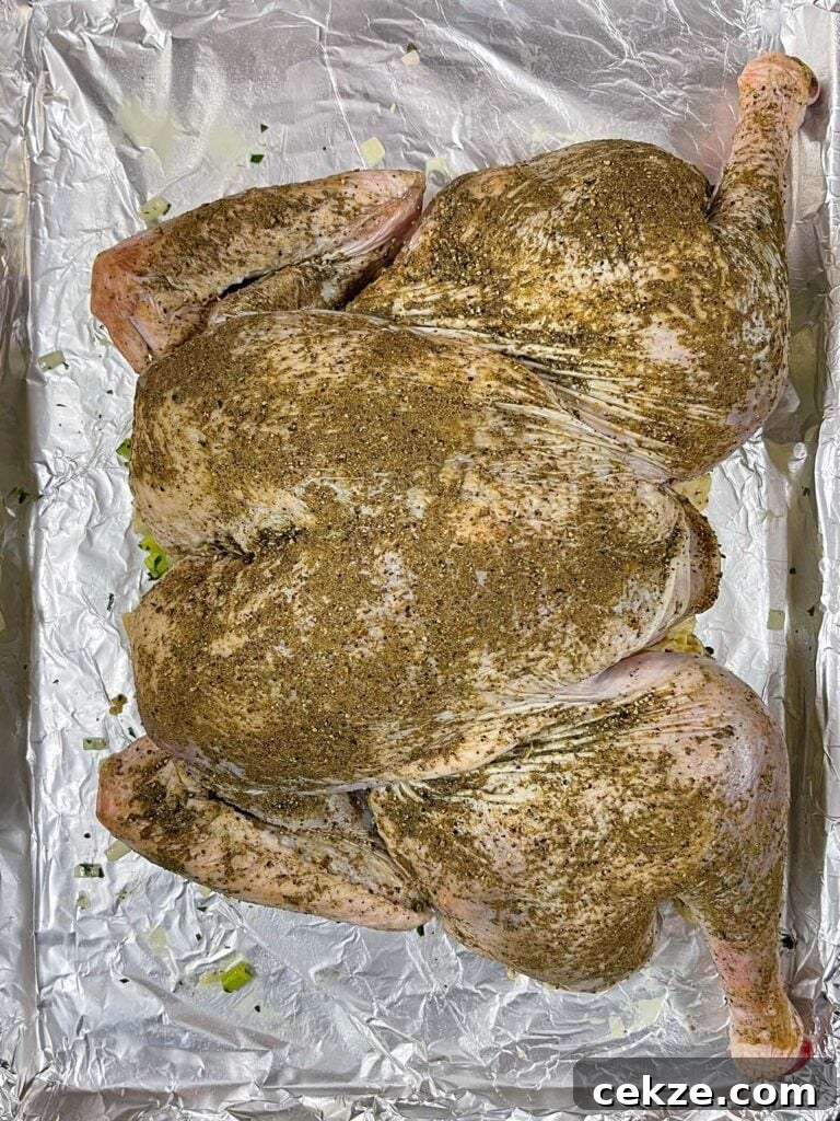Spatchcocked turkey positioned directly on top of the stuffing on a baking sheet.