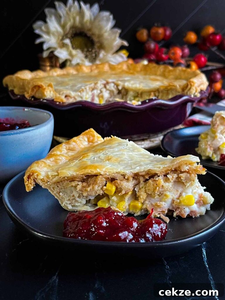 A slice of leftover Thanksgiving pie on a black plate.