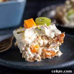 piece of icebox cake showing layers of cream, fresh fruits and cookies