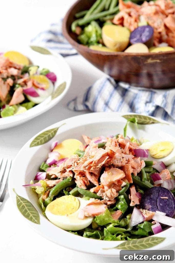 Grilled Salmon Niçoise Salad Recipe with Lemon Vinaigrette 4 salmon nicoise salad in two white bowls with green leaves