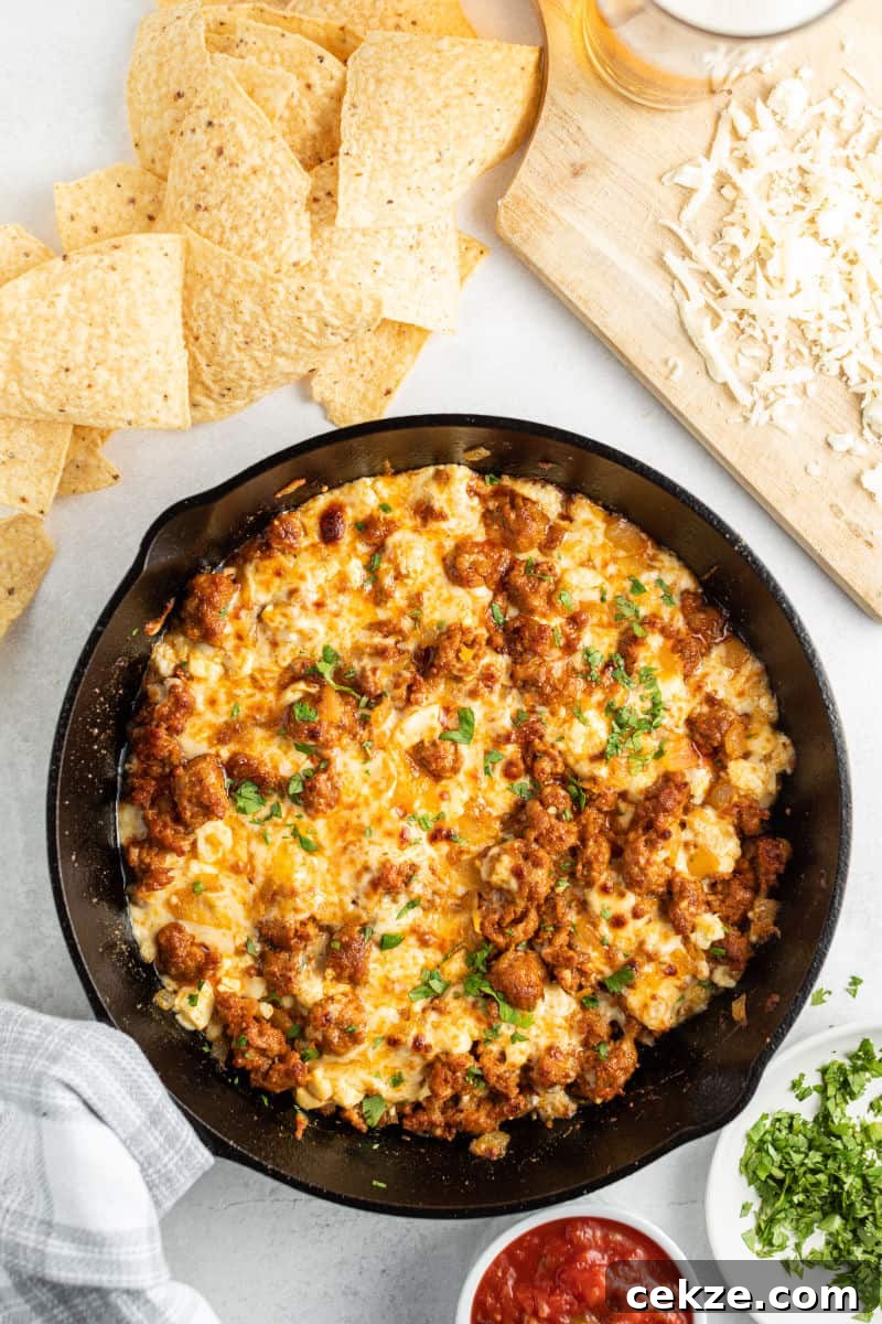 quesod fundido in a skillet with chorizo and chopped parsley on top