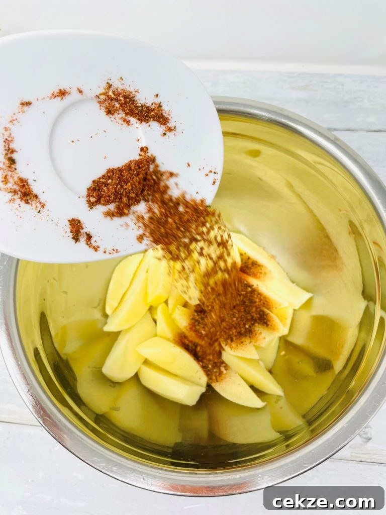peri peri seasoning being tipped into a bowl with wedges