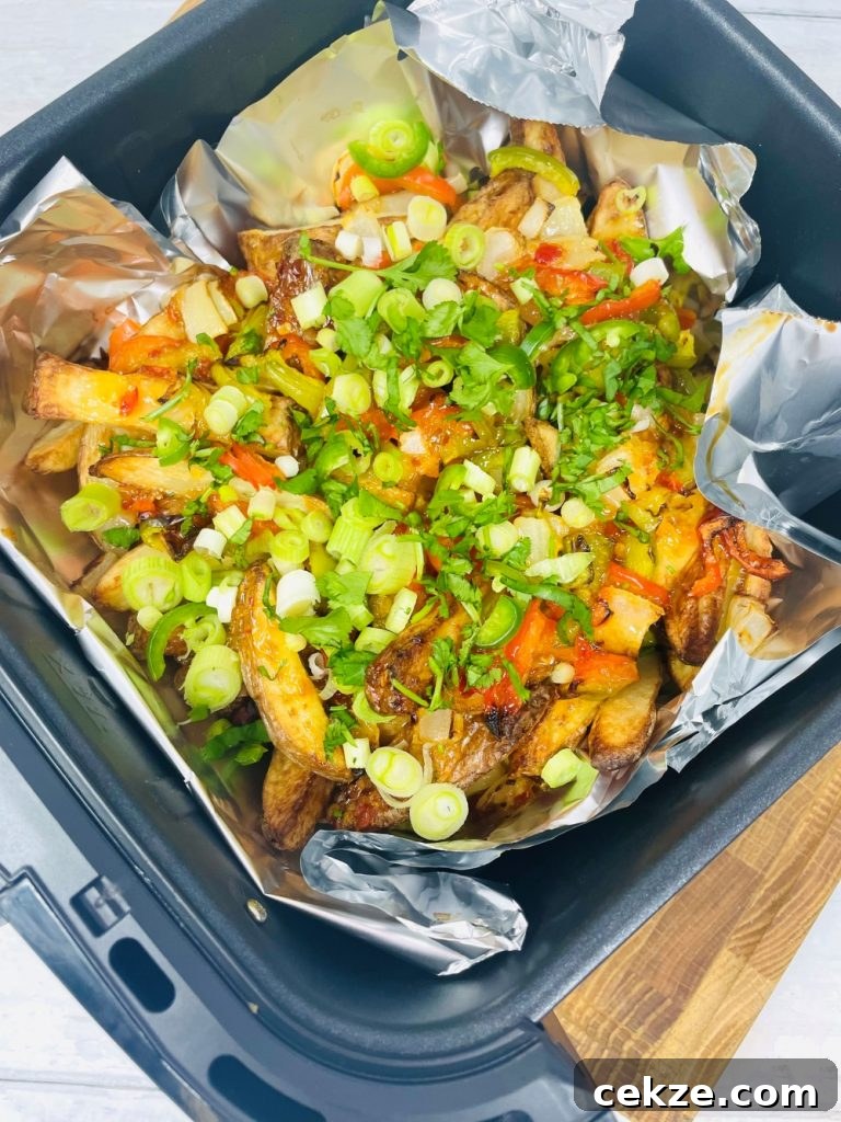 air fryer salt and pepper chips scattered with onions and coriander