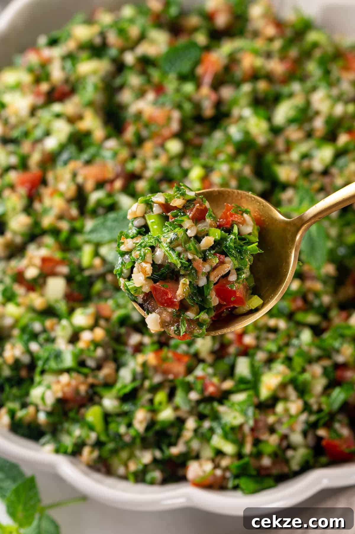 Spoonful of tabbouleh salad held over bowl