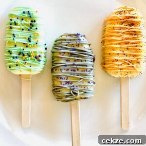 three halloween cake popsicles on a plate decorated with sprinkles