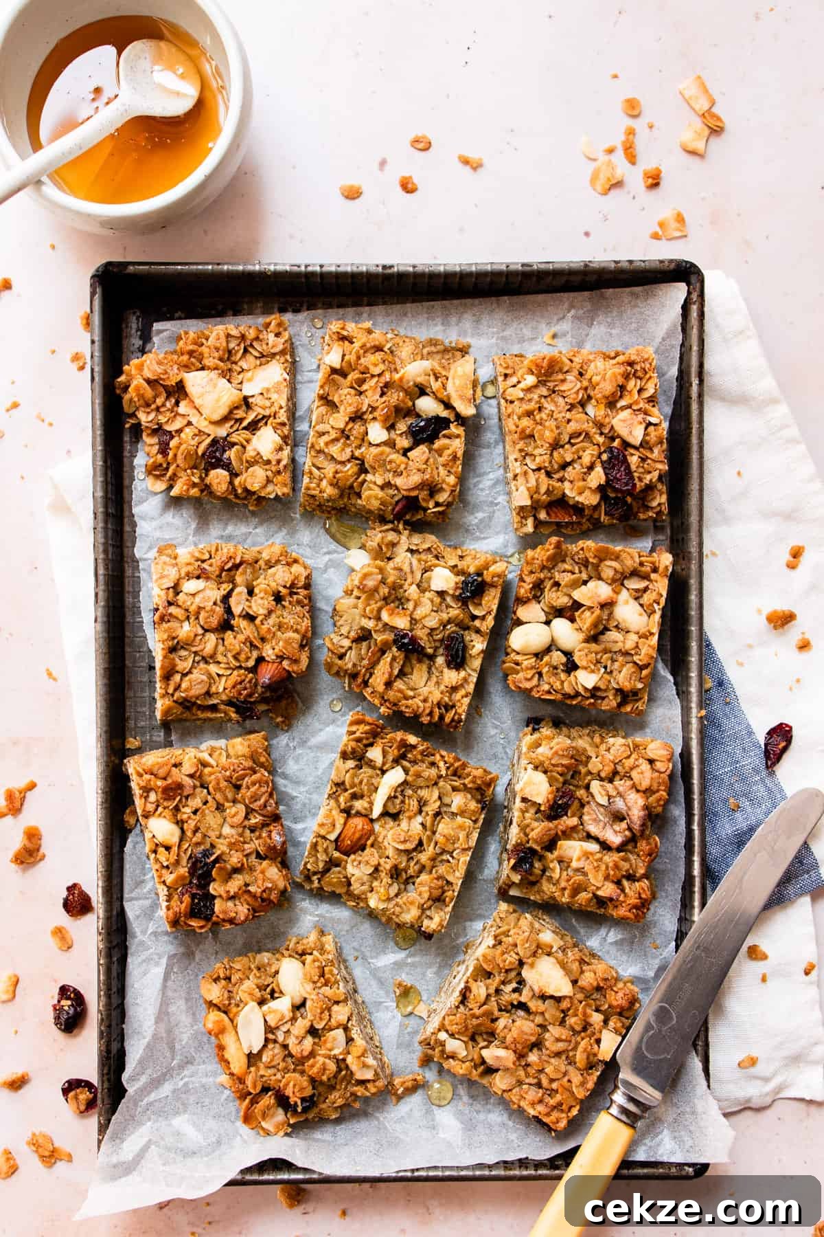 Chewy Oat Flapjacks with Berries and Maple Glaze 2 Healthy flapjacks on a baking tray with honey and nuts.