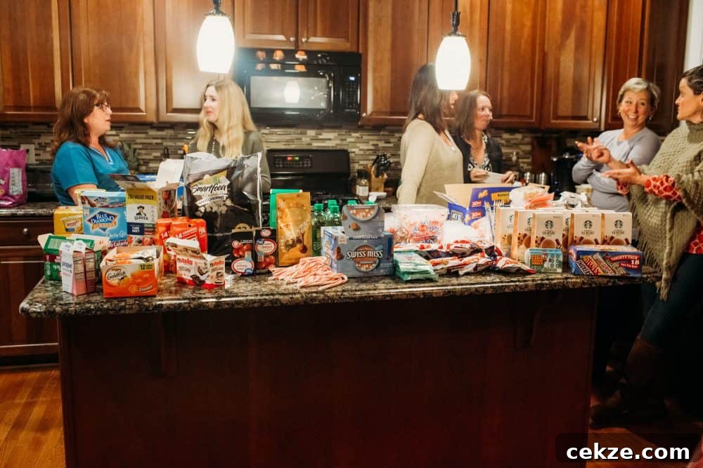 kitchen island covered with goodies to go inside a care package with moms standing around socializing
