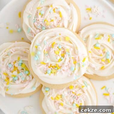 soft and buttery sugar cookies with frosting and sprinkles on a plate