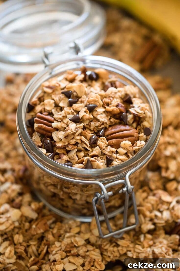 A jar filled with banana granola, with oats, chocolate chips and pecans.