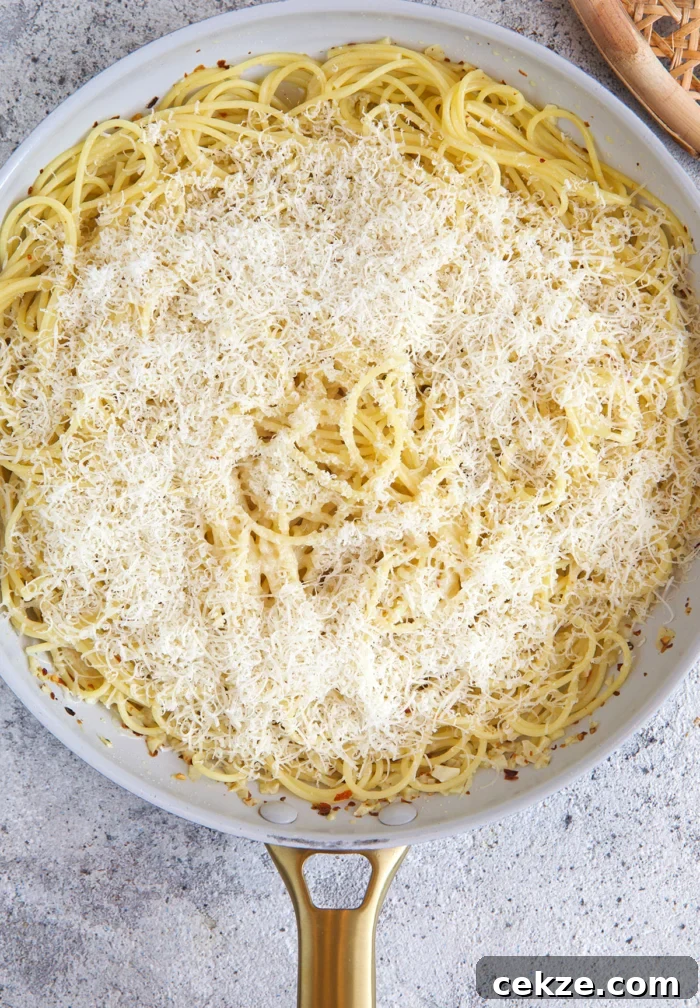 Classic Spaghetti Aglio e Olio: Simple Garlic Olive Oil Pasta Recipe 5 process of pasta with olive oil and garlic being cooked with cheese sprinkled on top