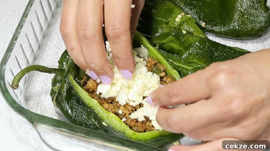 chiles rellenos being stuffed with cheese mixture