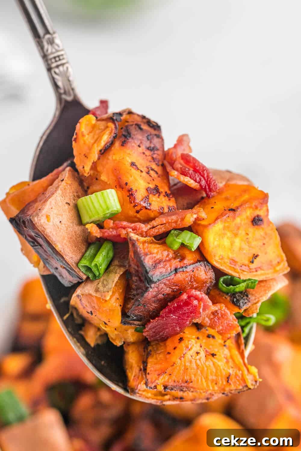 Sweet potato home fries on a spoon.