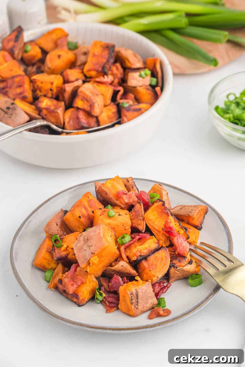 Sweet potato home fries on a plate with a fork.