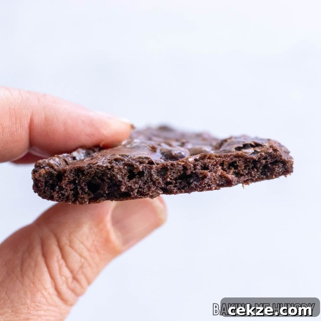 Crispy Brownie Brittle Recipe for Homemade Chocolate Snacking 12 hand holding a piece of brownie brittle