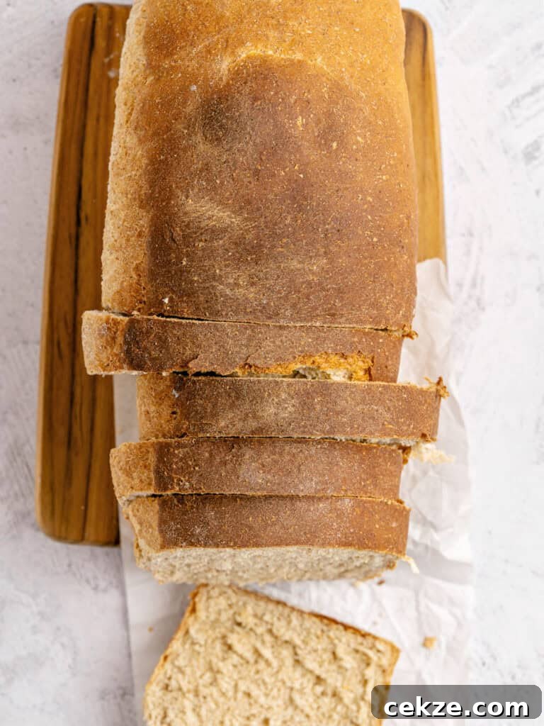 Homestyle Whole Wheat Sandwich Bread Recipe for Families 11 Top view of sliced loaf of whole wheat bread on a wooden board.