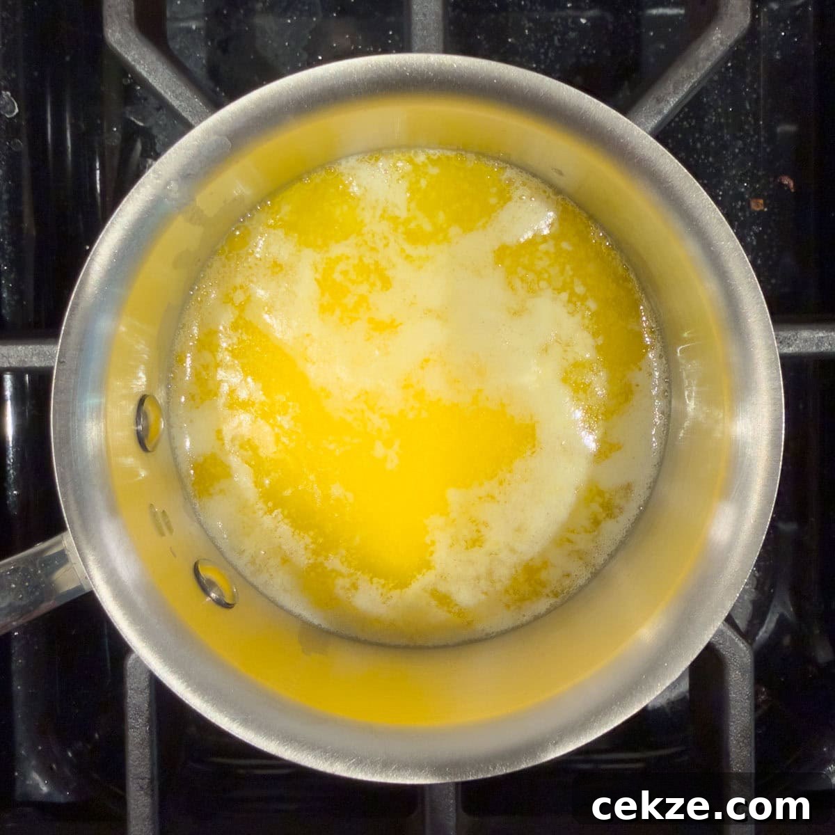 Golden melted butter in a small stainless steel pan.
