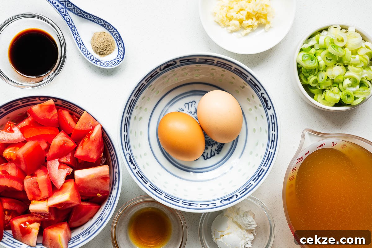 Ingredients prepared for tomato egg drop soup including chopped tomatoes and sliced scallions.