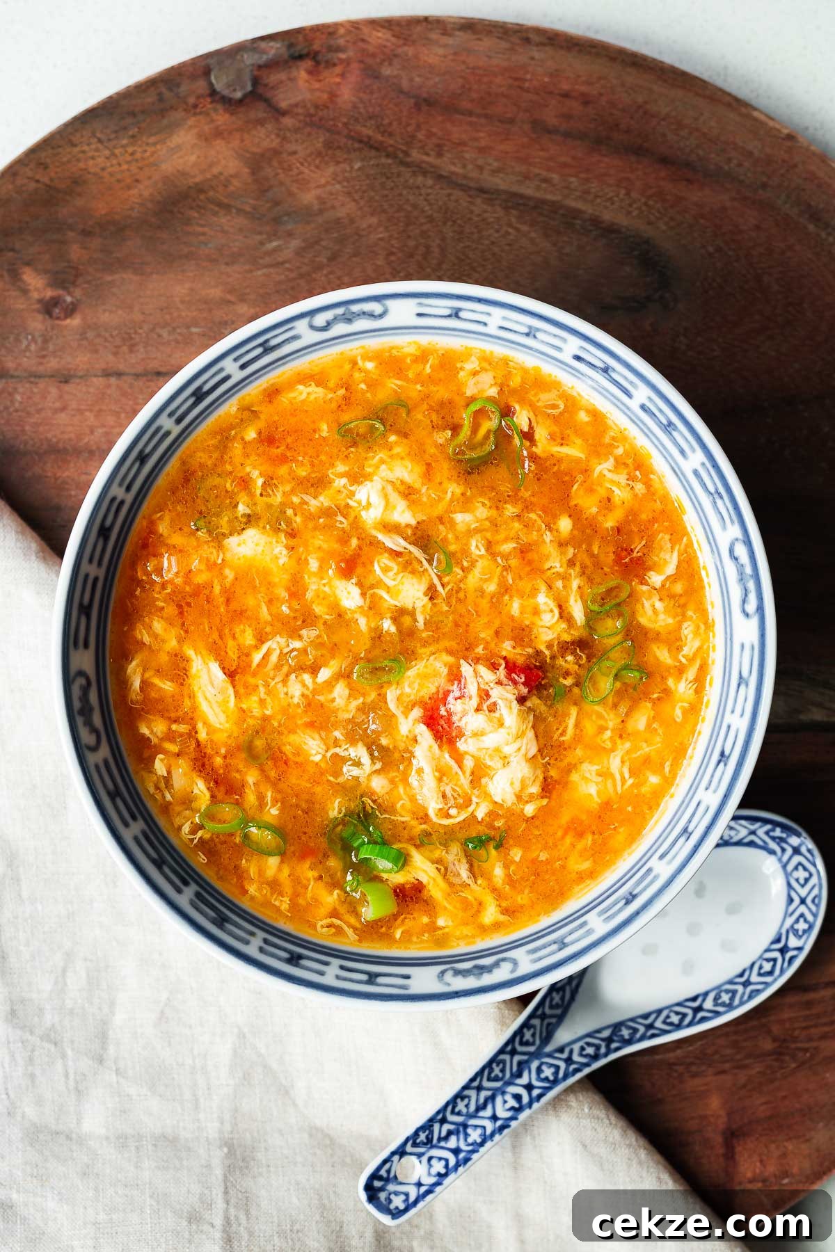 A Chinese bowl with tomato egg drop soup viewed from above.