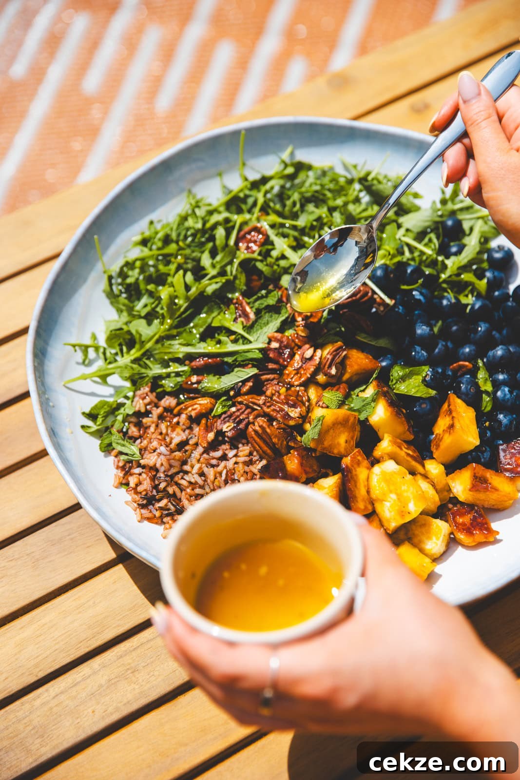 Pouring the dressing over Blueberry, Halloumi & Pecan Salad I Georgie Eats