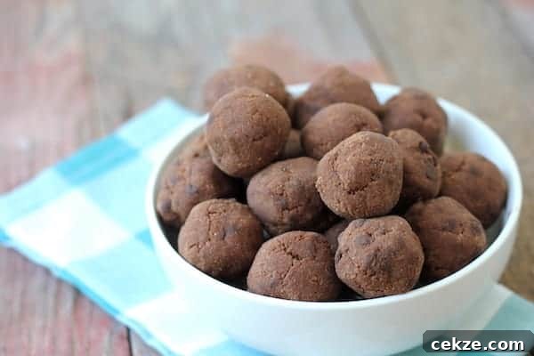 Double Chocolate Peppermint Cookie Dough Bites Recipe 3 Image shows a white bowl full of chocolate peppermint cookie dough balls sitting on a checkered napkin.