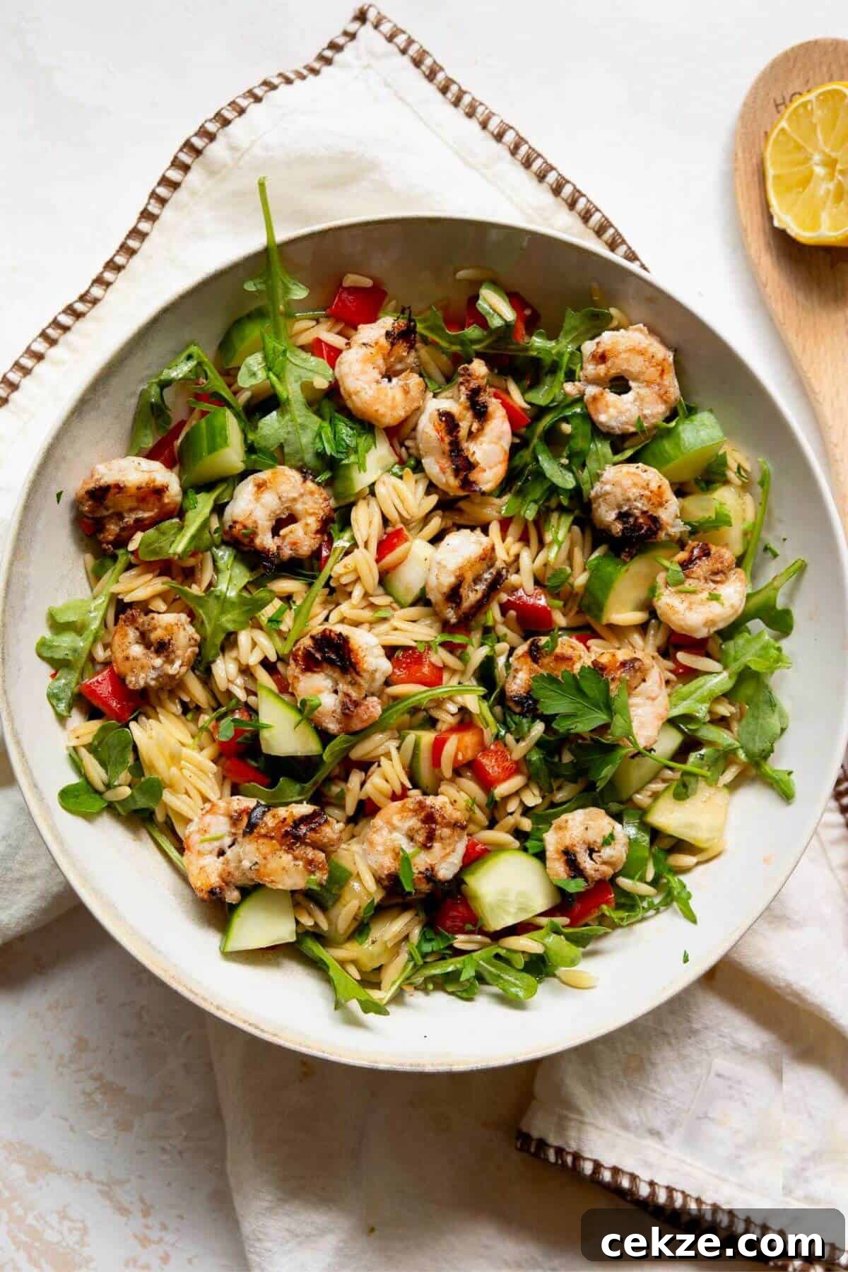Easy grilled shrimp orzo salad with arugula, cucumber, red bell pepper, and homemade balsamic vinaigrette.