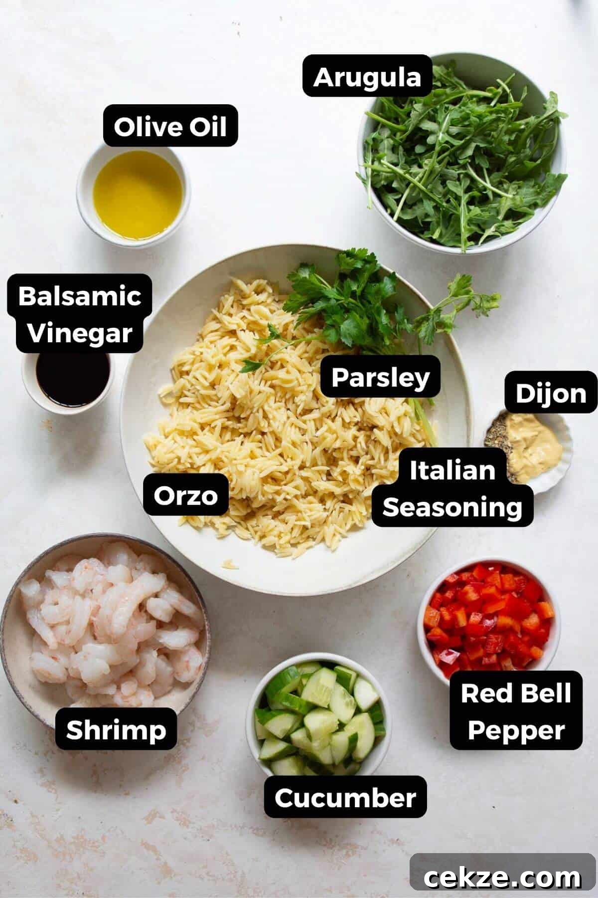 Ingredients for shrimp orzo salad laid out in bowls: shrimp, orzo, arugula, cucumber, red bell pepper, parsley, olive oil, balsamic vinegar, and Dijon.