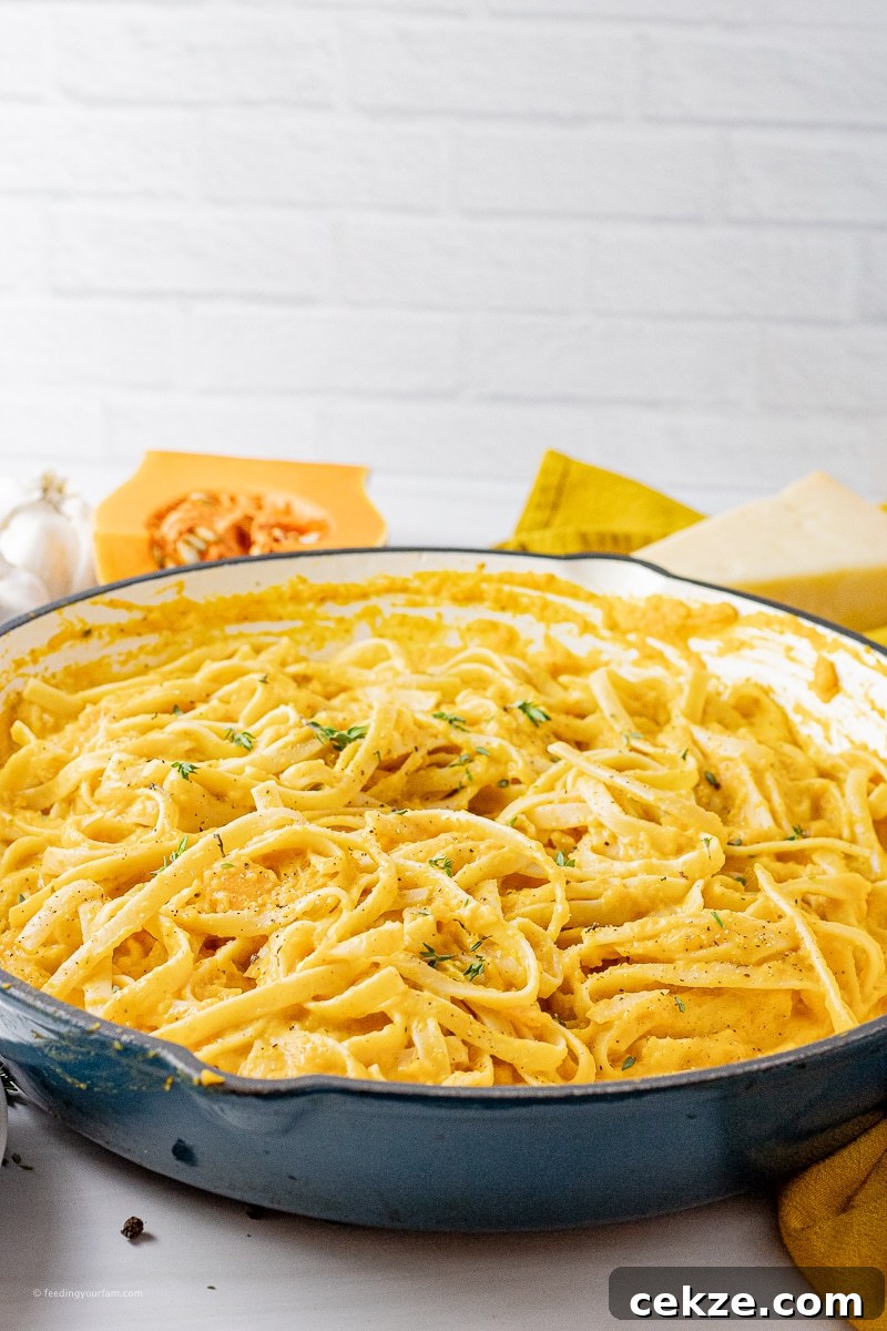 fettuccine noodles covered in a parmesan, butternut squash sauce in a large skillet