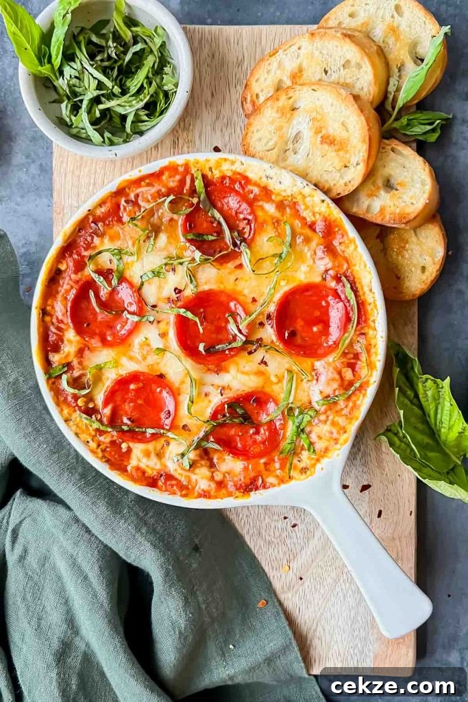 Feta, Bacon & Date Dip Recipe: Sweet Savory Party Appetizer 10 baked pepperoni pizza dip in white skillet garnished with fresh basil on serving board with baked crostinis.