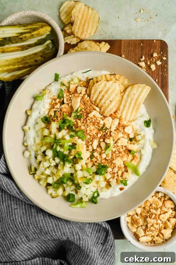 Feta, Bacon & Date Dip Recipe: Sweet Savory Party Appetizer 9 fried pickle dip in serving bowl garnished with crushed crackers, green onion, and chopped pickles.