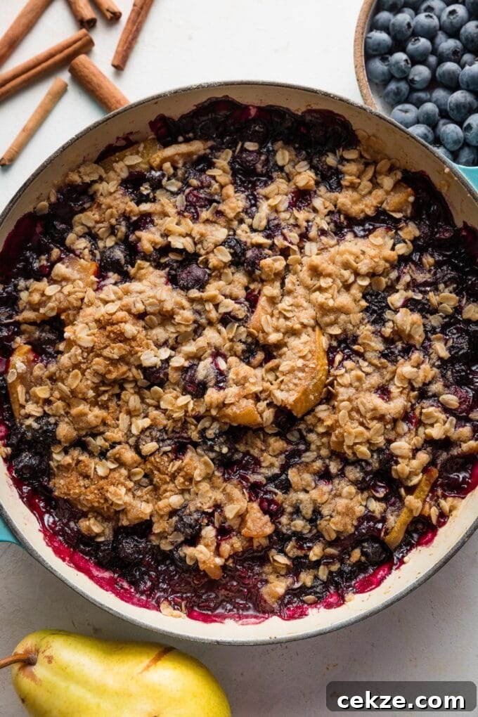 Pear and Blueberry Crisp Recipe for Warm, Fruity Dessert 3 Overhead view of a blueberry pear crisp just baked in an enameled cast iron skillet.