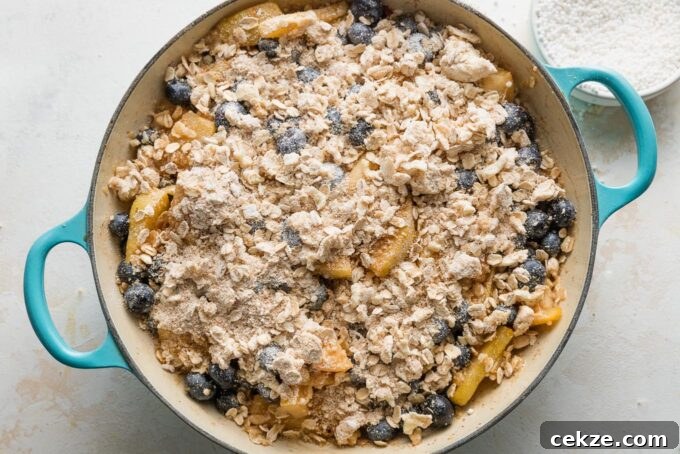 Pear and Blueberry Crisp Recipe for Warm, Fruity Dessert 7 Buttery oat topping spread on top of a blueberry pear fruit dessert filling.
