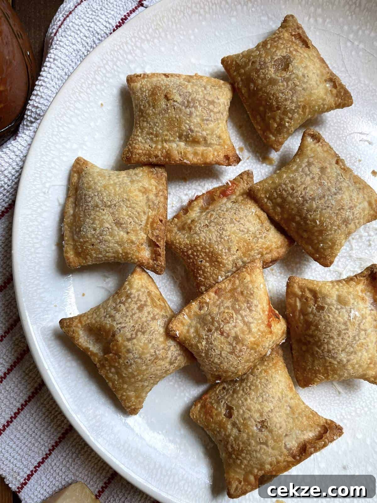 Air fried pizza rolls on a white plate.