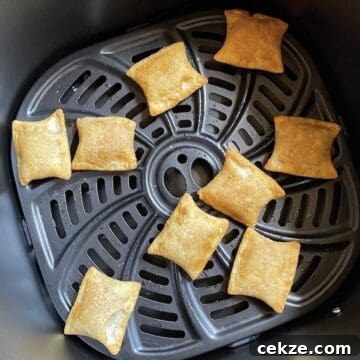 Cooked pizza bites in the basket of a Gourmia Air Fryer.