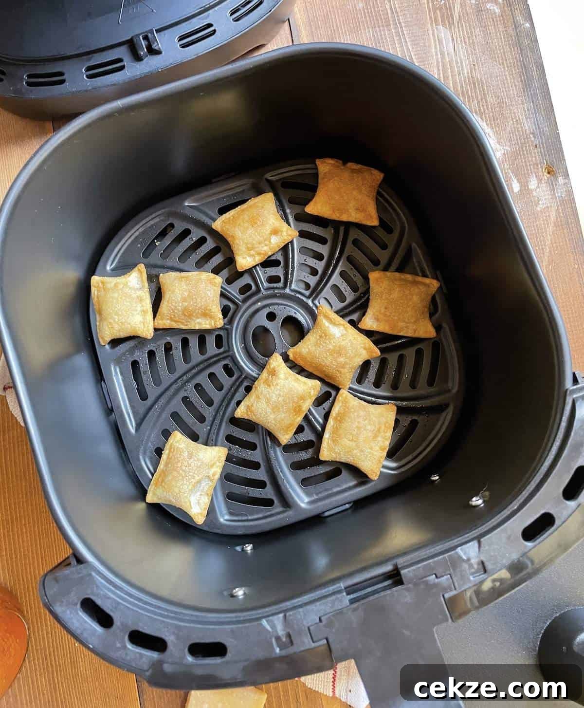 Cooked pizza rolls in the basket of a Cosori Air Fryer.