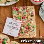 Break-and-Bake Christmas Cookie Dough Tips for Perfect Cookies 7 Wrapped break and bake Christmas cookie dough with festive toppings and a “Cookies for Santa” label.