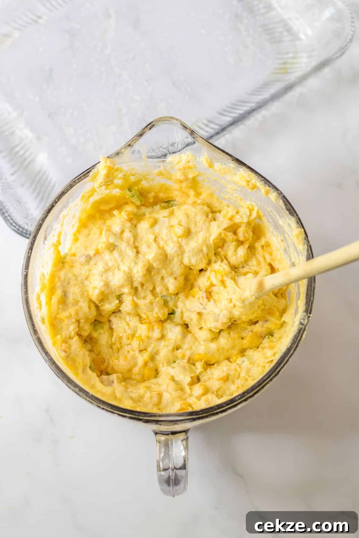Loaded Cornbread Casserole Recipe — Cheesy Bacon & Jalapeño Bake 6 cornbread mixture in a glass mixing bowl.