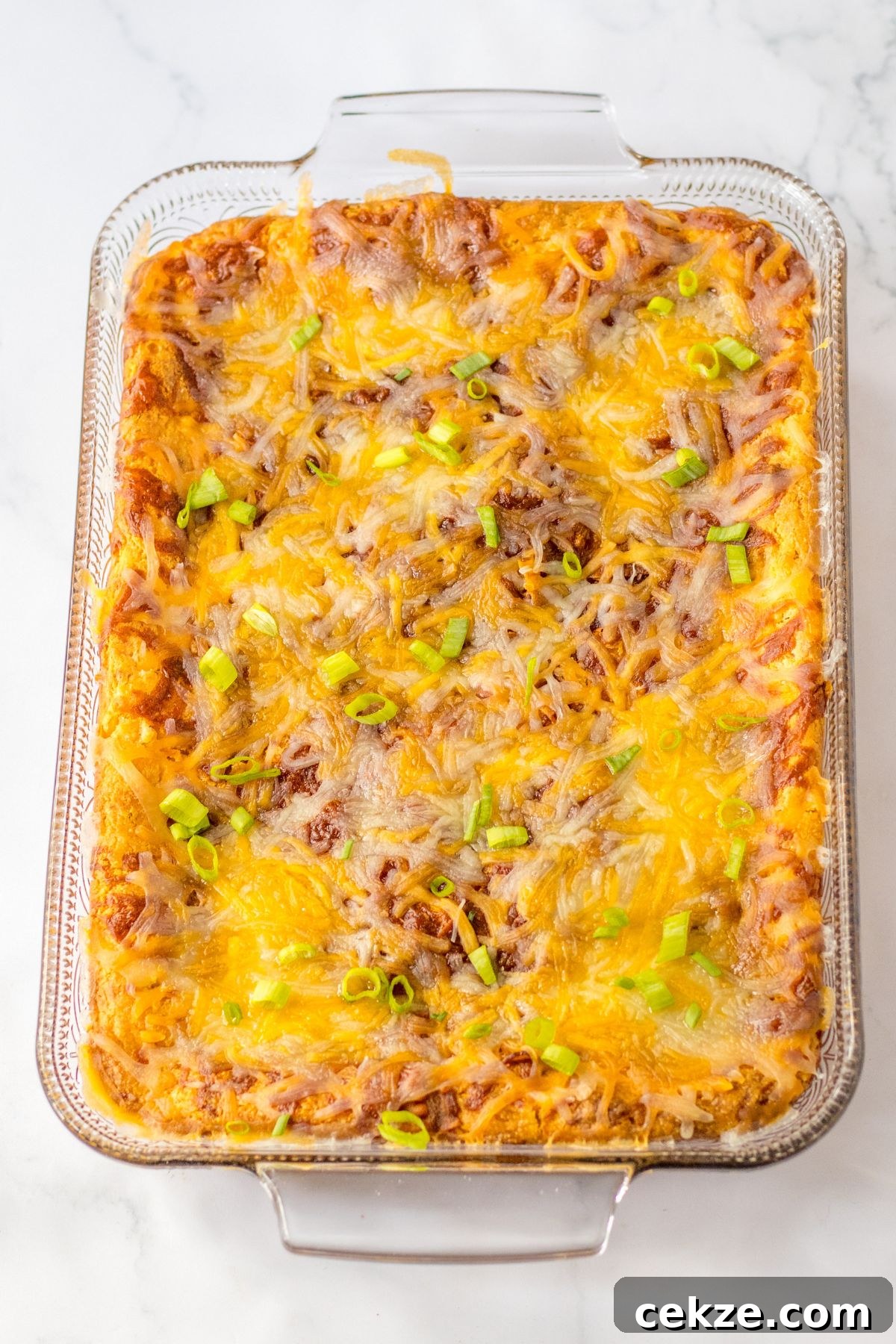 Loaded Cornbread Casserole Recipe — Cheesy Bacon & Jalapeño Bake 7 baked loaded corn casserole in a glass baking dish.