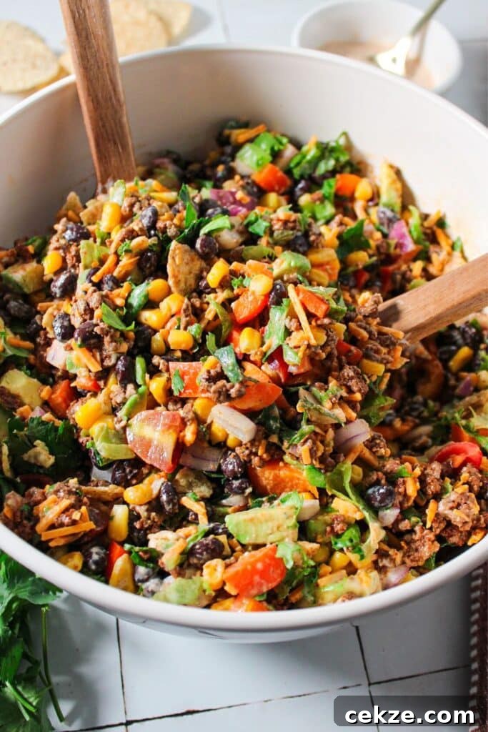 A close up shot of taco ground beef salad tossed with dressing.